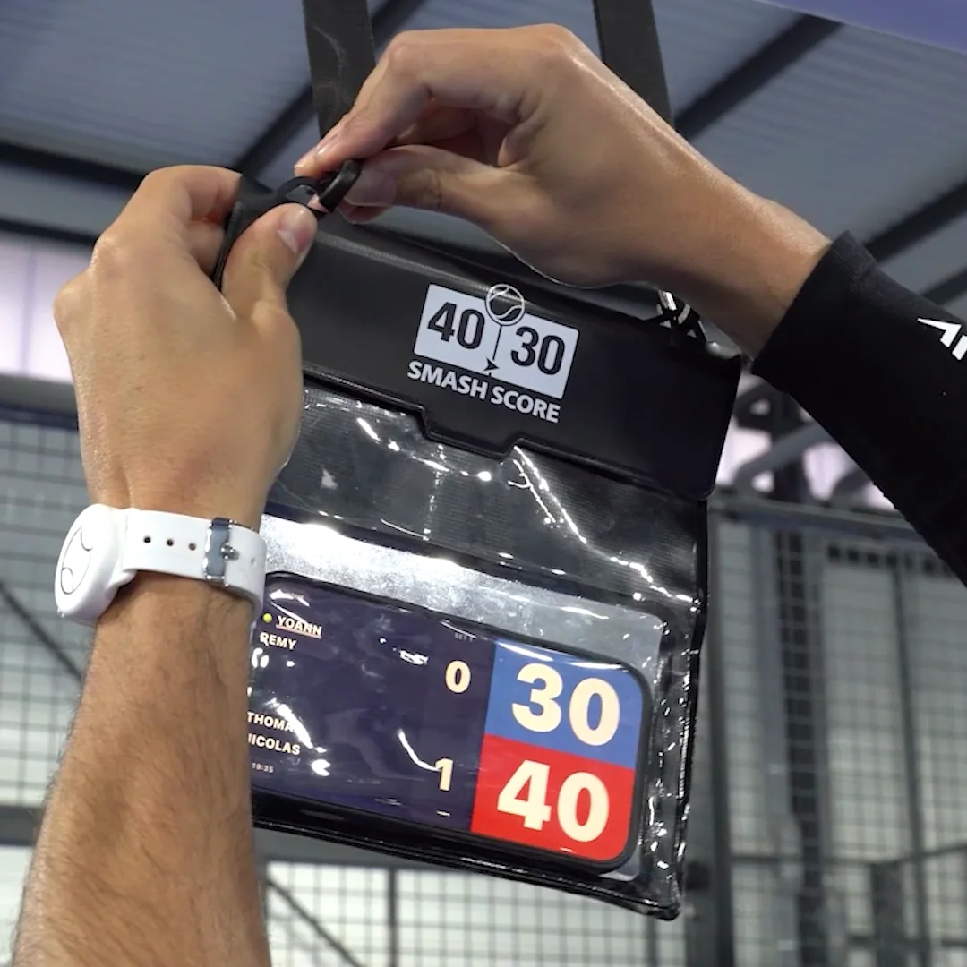The phone holder clipped to the fence, score showing